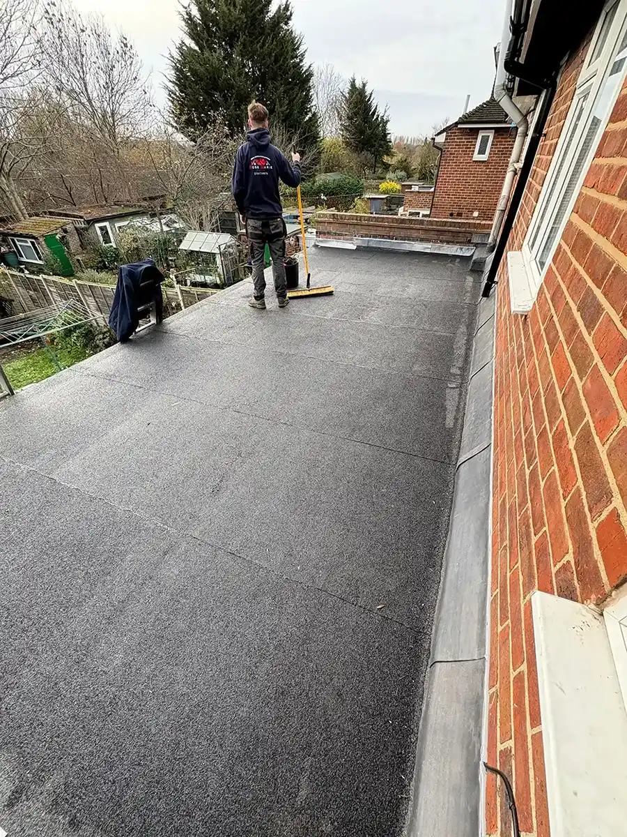 A man is cleaning the roof of a house.