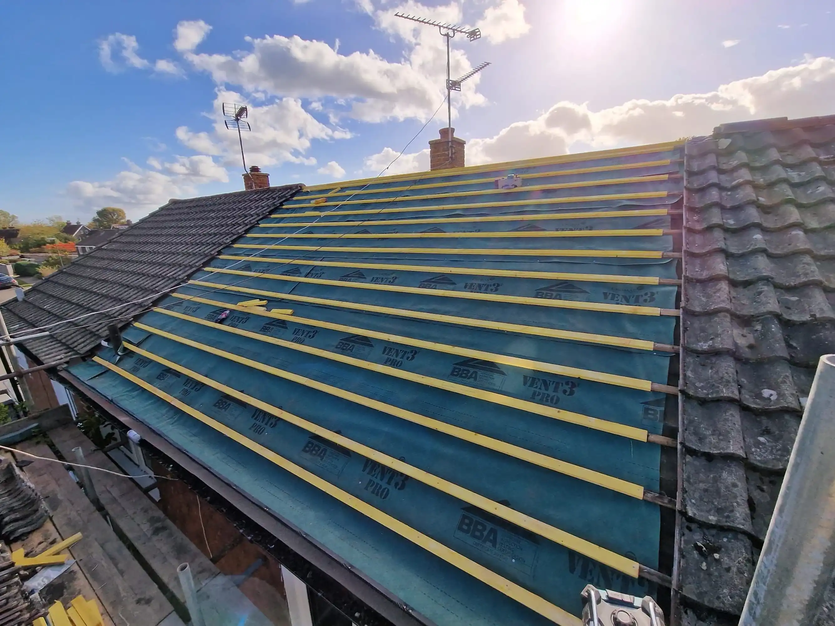 New tiles being put on the roof of a house.
