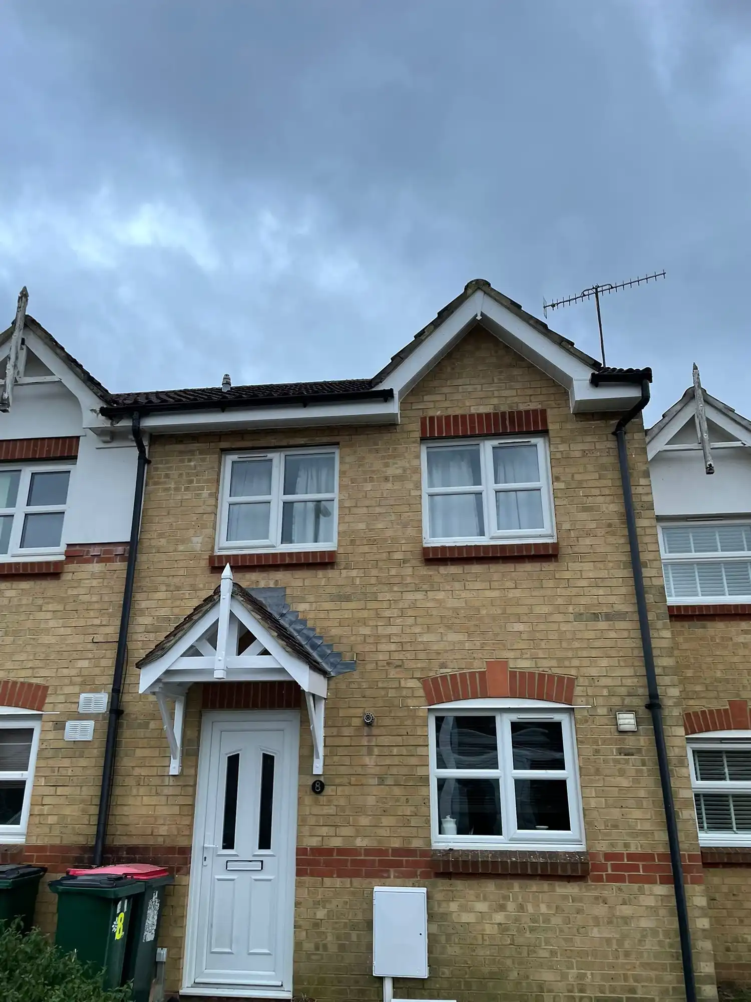 A brick house with a white door and windows.